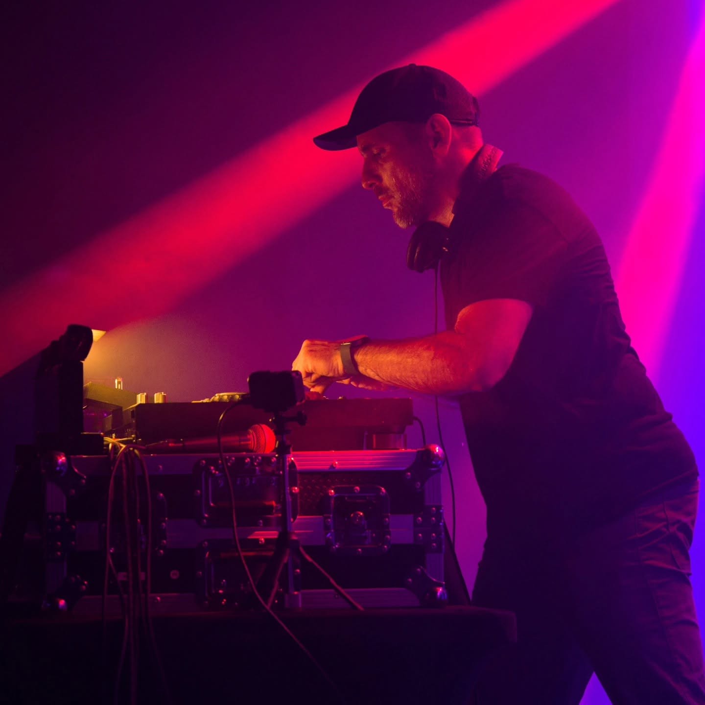 Fonkah performing behind the decks at Torch under magenta stage lights